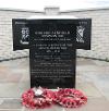 The memorial stands on part of the main runway on the south side of Park Lane, Langham.
