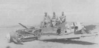 Servicemen on top of a crashed enemy fighter